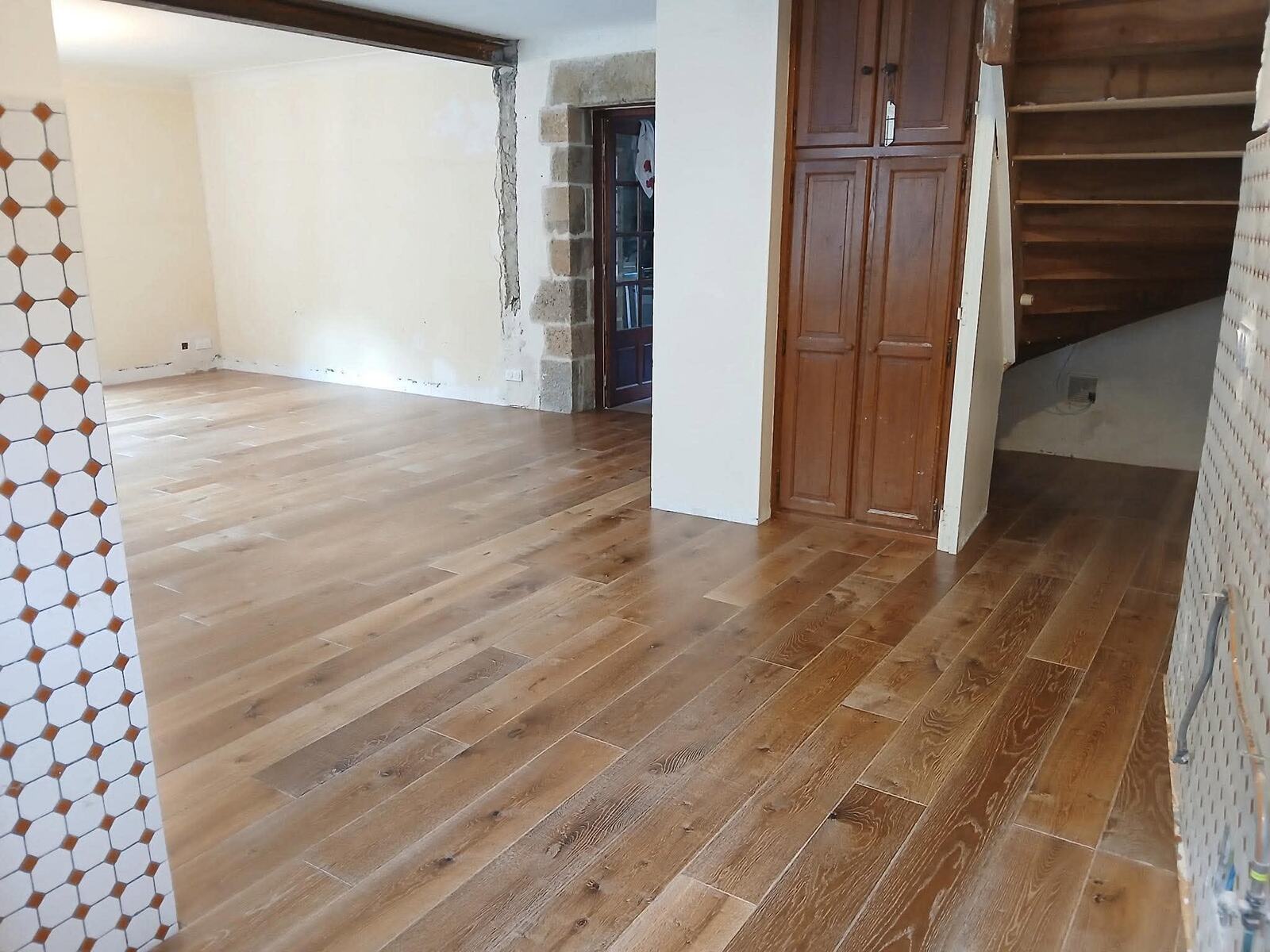 Grande pièce avec parquet chêne aux lames larges, lumière des fenêtres sur le bois